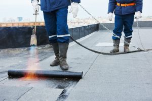 Wrokers using torch to seal flat roof