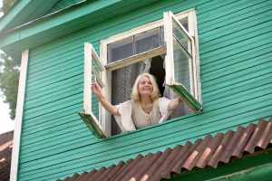 Lady leaning out a window, improving indoor air quality