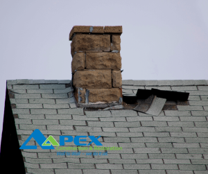 Chimney on a roof with loose shingles, sign your roof might be leaking there