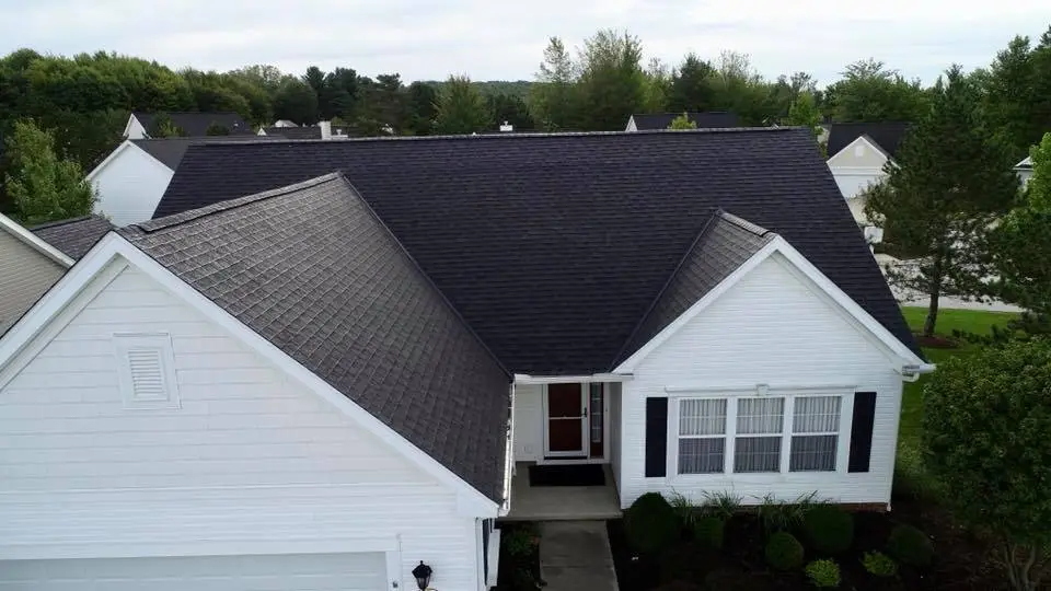 Arial view of a white house with a fresh new black asphalt roof