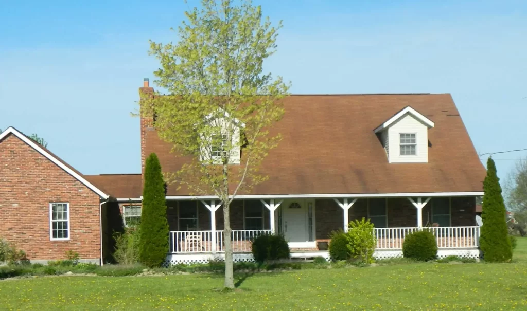 Ranch style home with visible wear and tear on asphalt roof