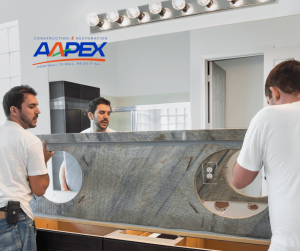 Two workers installing a countertop in a bathroom. Aapex logo top left.