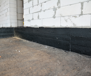 A waterproofing sealant on a homes foundation.