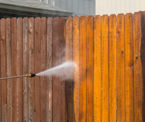 Power washing wooden fence.